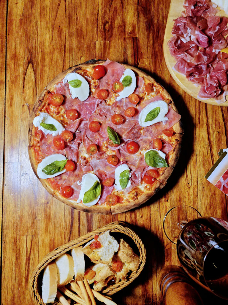 Pizza with Parma ham, burrata, cherry tomatoes, and basil at Limoncello